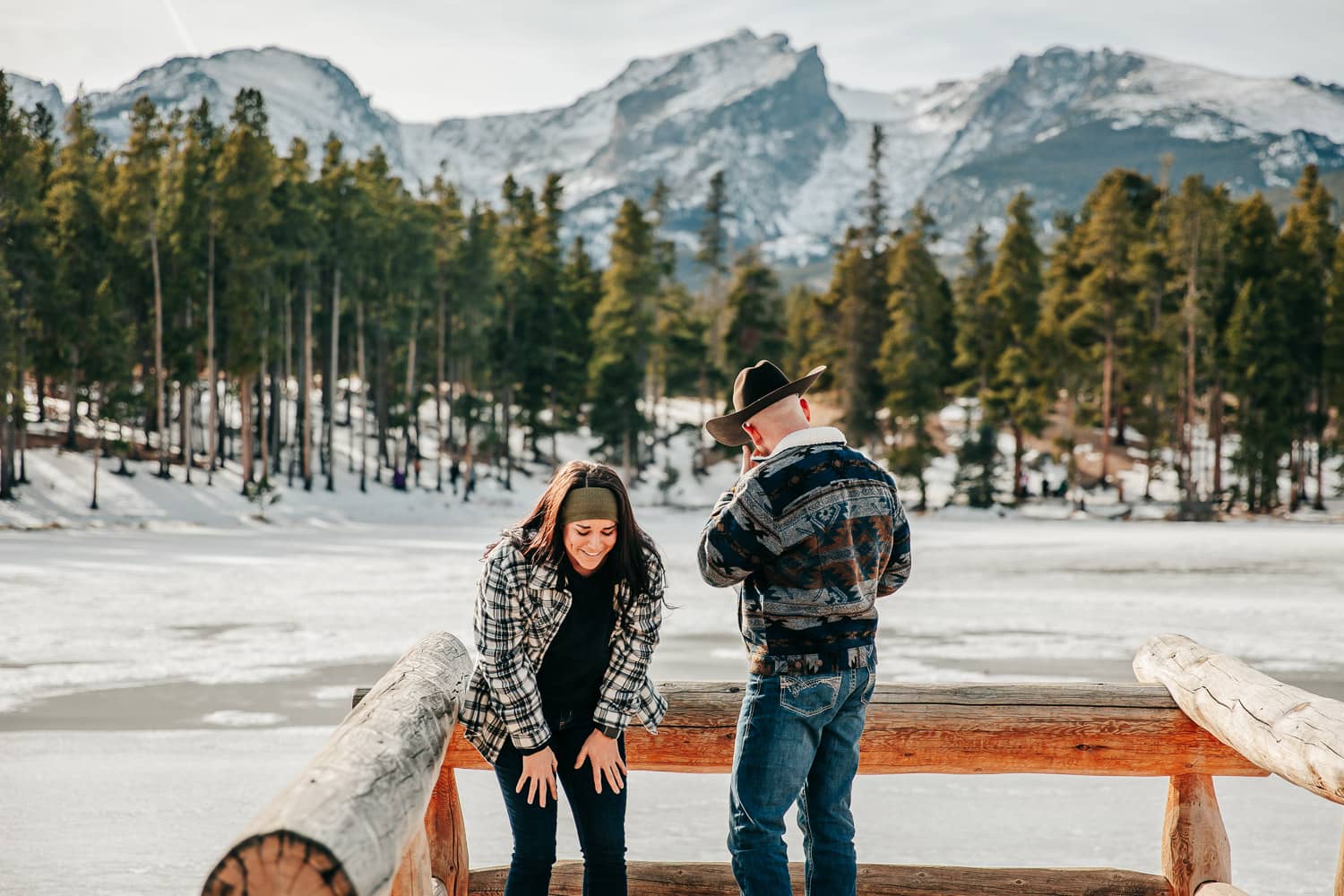 A couple right after their proposal in Rocky Mountain National Park. The girl is excited and has her hands on her knees, the man is wiping a tear away.